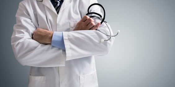 Doctor holding a stethoscope with arms crossed and copy space